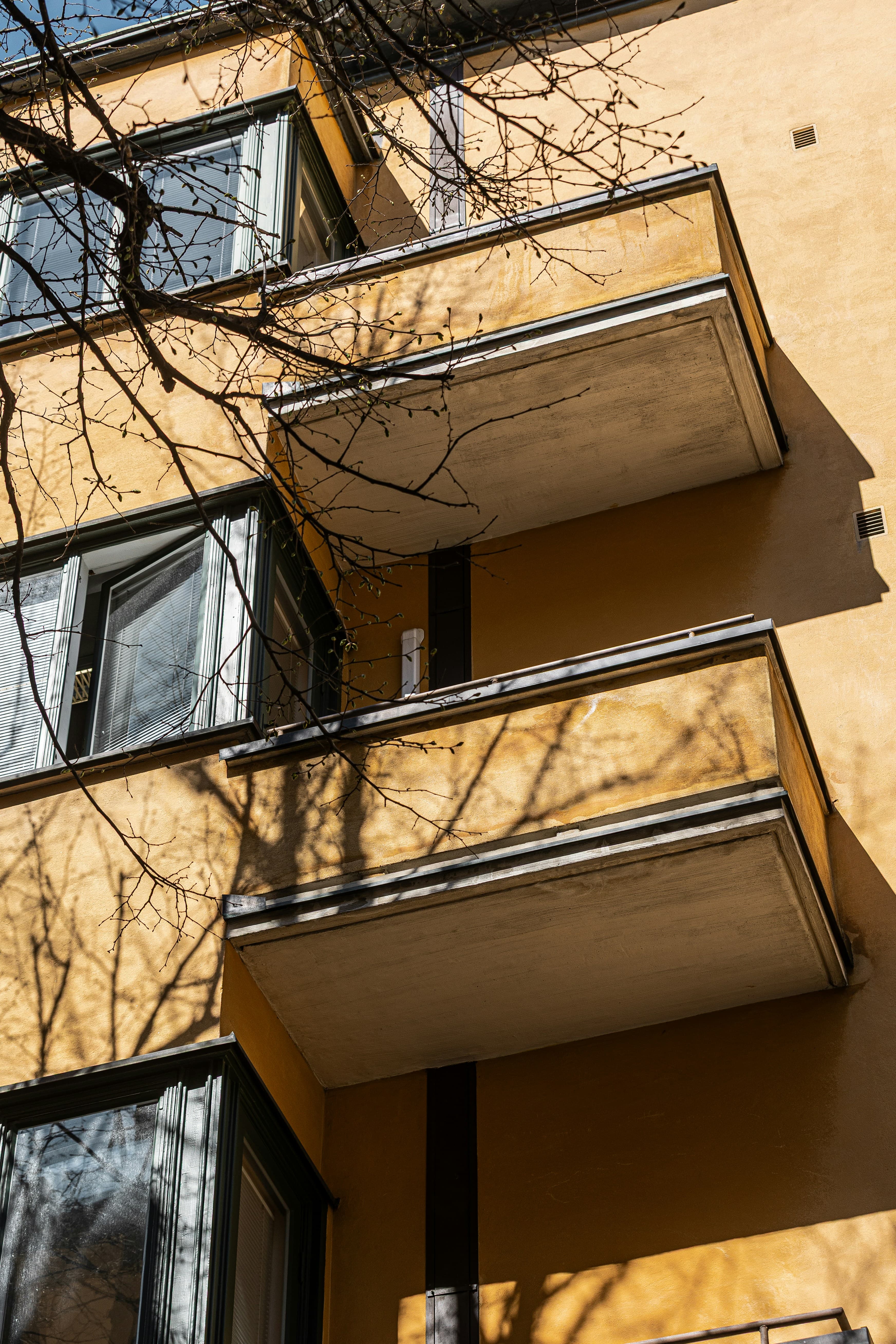 Fasad med balkonger i kvällsljus.